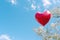Heartshaped balloon soaring in blue sky