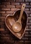 Heartshaped wood bowl and spoon on wooden backcloth top view