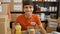 Heartwarming portrait of a young, handsome hispanic man, smiling confidently while volunteering at a charity center, sitting at a