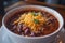 Hearty Bowl of Chili Topped with Cheese and Parsley