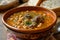 A hearty bowl of soup filled with tender meat and flavorful beans, simmering in a rich broth, A warm, comforting bowl of chickpea