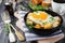 Hearty breakfast. Hash brown potatoes, chicken, onion, parsley, oregano and a fried egg in a frying pan on the old wooden