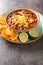 Hearty chicken taco soup packed with black beans, corn, and tomatoes with green chile peppers close-up in a plate. Vertical