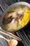 Hearty and comforting Korean rice cake soup Tteokguk closeup in the bowl. Vertical
