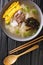 Hearty and comforting Korean rice cake soup Tteokguk closeup in the bowl. Vertical top view