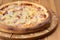 Hearty italian pizza on a wooden board. pizza with ham,
