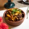 Hearty lunch. Clay pot with baked meat and potatoes. Delicious stew with greens. Close up shot. Soft focus