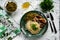 A hearty meal on the table, spaghetti with fried pork chunks, green canned peas and watercress grass. Next to the sauce