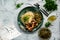 A hearty meal on the table, spaghetti with fried pork chunks, green canned peas and watercress grass. Next to the sauce