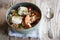 Hearty oat flakes bowl with fruits, goat cheese and thyme.