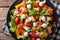 Hearty salad with salmon, mozzarella and fresh vegetables close-up on a plate. horizontal top view