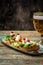 Hearty snack with different kinds of spreads on farmhouse bread served with a fresh yeast wheat beer on an old wooden table. Beer