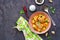 Hearty stew with potatoes, carrots and chicken meat balls in a pink bowl on a dark concrete background. Copyspace