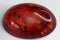 Heat-treated deep orange amber cabochon crystal