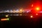 Heathrow airport tarmac on a rainy night with British Airways plane readying for takeoff and lights reflecting off wet surfaces -