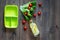 Heathy meal in office. Lunch box with tomato and salad on dark wooden background top view copyspace