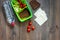 Heathy meal in office. Lunch box with vegetables, cheese and bread on dark wooden background top view copyspace