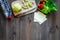 Heathy meal in office. Lunch box with vegetables, cheese and bread on dark wooden background top view copyspace