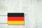 Heating battery, in the colors of the Germany flag on a concrete wall. Copy space. Raising heating prices. Heat saving