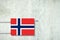 Heating battery, in the colors of the Norway flag on a concrete wall. Copy space. Raising heating prices. Heat saving