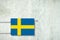 Heating battery, in the colors of the Sweden flag on a concrete wall. Copy space. Raising heating prices. Heat saving