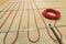 Heating red electrical cable wire roll on cement floor copy space background. Renovation and construction, comfortable warm home