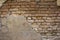 A heavily destroyed old gray concrete wall with red bricks. rough surface texture