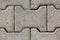 Heavily used old densely laid I shaped concrete tiles at path in local public park texture background wallpaper