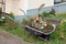 Heavily used retro vintage wheelbarrow construction cart remade to be used as garden decoration with two carved out squashes and