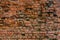 Heavily weathered brick wall texture and background with deep water erosion and even some sprouts