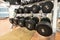 heavy black metal dumbbells for strength training on rack.