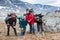 Heavy breathing hikers with big backpacks standing on mountain pass, four people have climbing tour together