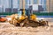 Heavy bulldozer on the construction of sewage and heating communications under the road, amid multi-story residential buildings