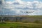 Heavy cargo airplane landing on runway with lush green and blue sky