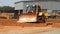 Heavy caterpillar bulldozer working in quarry. Yellow excavator moving ground