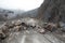 Heavy chain and wheeled equipment clears the highway after a rock collapse