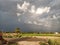 Heavy clouds in village with fields