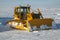 Heavy Crawler Bulldozer clears snow on the roads