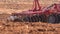 A heavy crawler tractor plows and buries a field in early spring, a plowed field for crops.