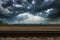 Heavy dark rain clouds over an open field