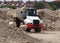 Heavy dump truck among dunes of gravel of a new development area