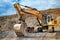 Heavy duty excavator loading soil material from highway construction site