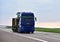 Heavy duty tractor unit with push-pull MAN ransporting wheel loader. Semi-trailer truck on highway. Logistics of transportation of