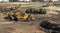 Heavy earthmoving equipment including scapers and motor graders involved in grading operations