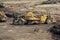 Heavy earthmoving equipment including scapers and motor graders involved in grading operations