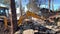 Heavy equipment near the destroyed brick house. Construction machinery on the background of the ruins of the house. Demolition of