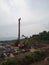 heavy equipment is seen operating around an industrial nickel mine next to a motorbike parking lot