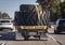 Heavy equipment tires being hauled on a flatbed trailer with straps and a a wide load sign