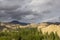 Heavy evening sky over sandy mountains and forest