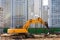 Heavy excavator in a working high frequency hydraulic vibratory mounted pile driver on road against the background of residential